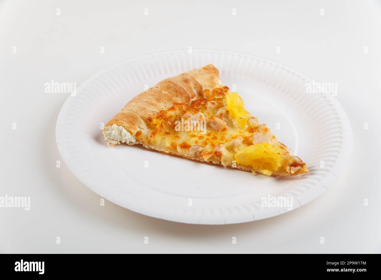 Ein Stück hawaiianische Pizza mit Huhn und Ananas mit Käseplatte auf Papierteller isoliert auf weißem Hintergrund. Stockfoto