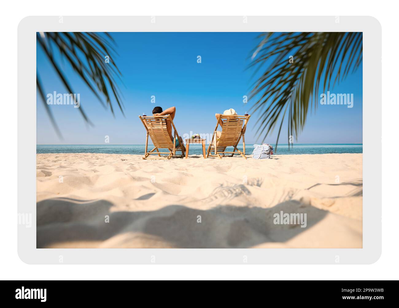 Papierfoto. Ein Paar mit Wein am Sandstrand des Resorts Stockfoto
