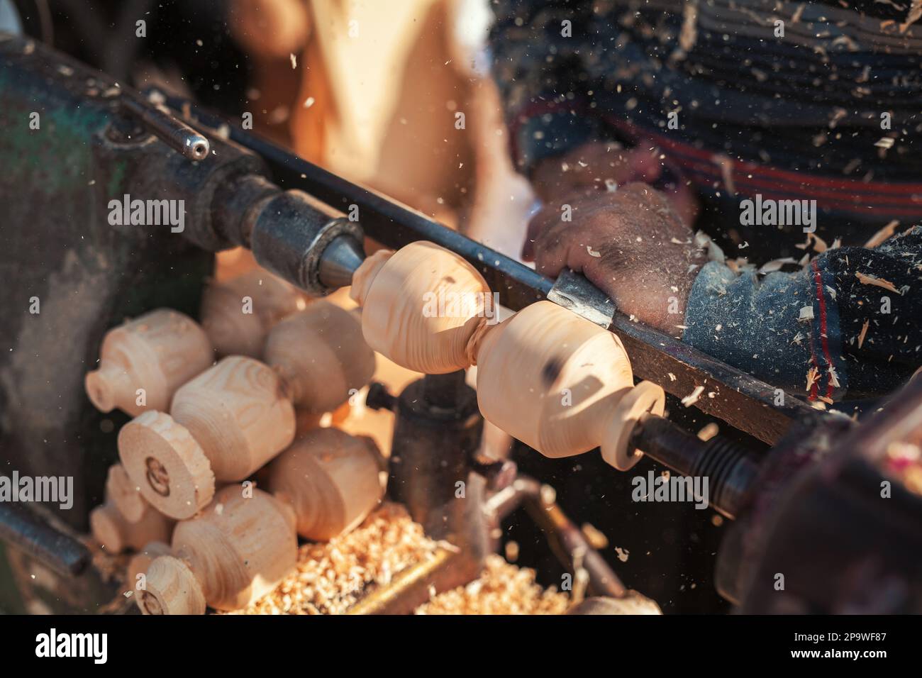 Handgefertigte Produktionsstufe des Spinning Top. Ein Holzschnitzer, der das Holz auf der Werkbank schnitzt. Stockfoto