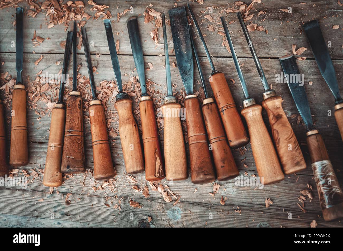 Draufsicht auf Holzmeißel zum Schnitzen von Holz auf dem Holztisch. Detail aus der Holzarbeiter-Werkstatt. Stockfoto