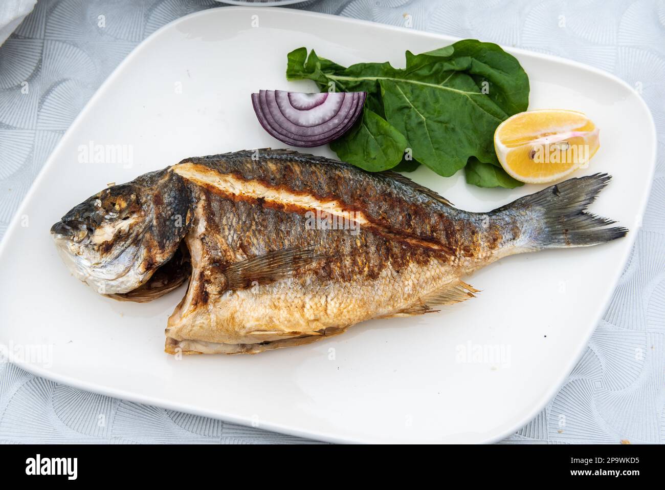 Die Platte von der Dorade Fisch mit Pommes Frites und Salat in der ...