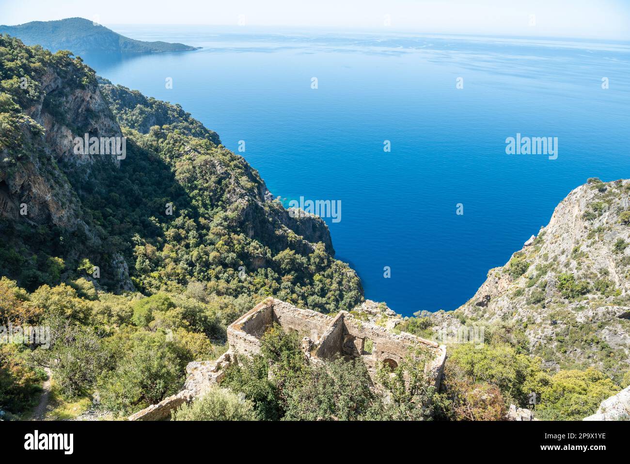 Mediterrane Küste in der Nähe des Dorfes Kayakoy in der Provinz Mugla der Türkei mit Ruinen des Klosters Afkule. Das griechische Kloster wurde in den 192 Jahren verlassen Stockfoto