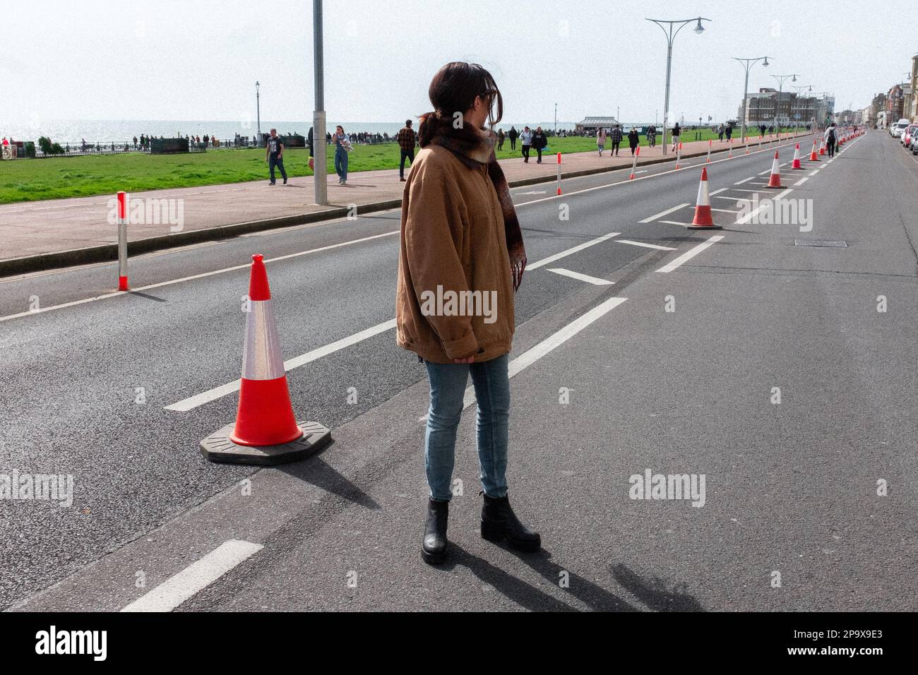 Woman steht in geschlossenem Kingsway für den Marathon an Hove Seafront, Brighton & Hove, East Sussex, Großbritannien Stockfoto