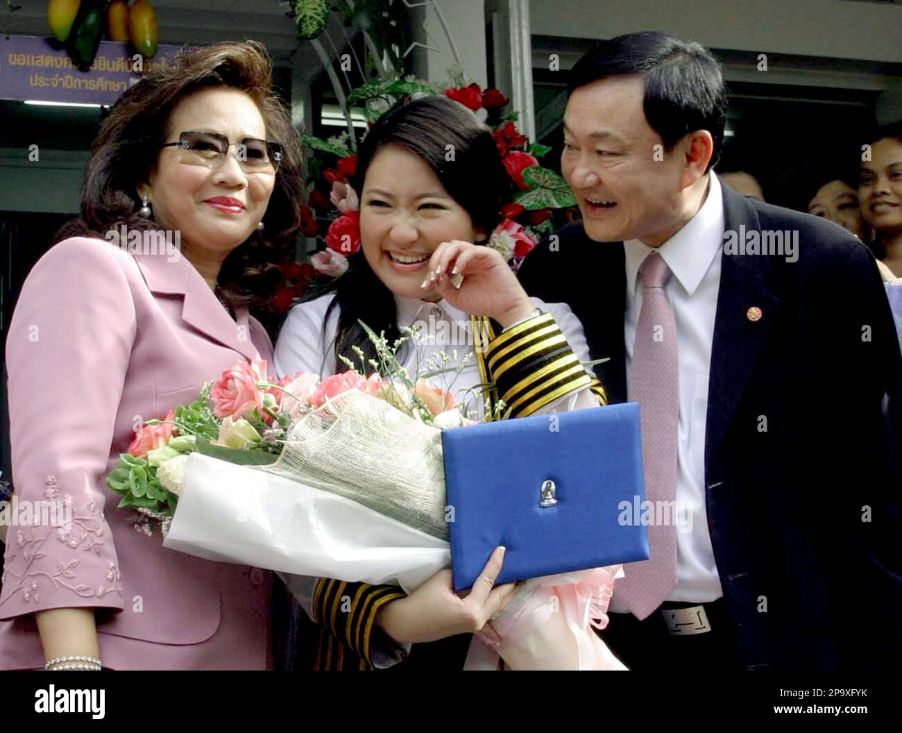 Thailand's former Prime Minister Thaksin Shinawatra, right, and his wife, Pojaman, left, pose with their youngest daughter Paethongtarn Shinawatra after her university graduation ceremony, Thursday, July 10, 2008, in Bangkok, Thailand. (AP Photo) Stockfoto