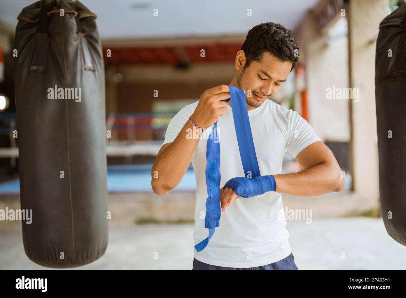 Ein asiatischer Boxer, der Boxhandschuhe trägt, während er im Ring steht Stockfoto