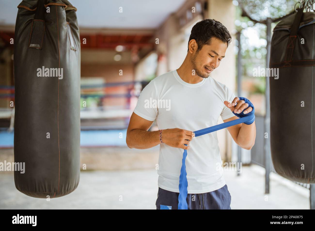 Ein asiatischer Boxer, der Boxhandschuhe trägt, während er im Ring steht Stockfoto