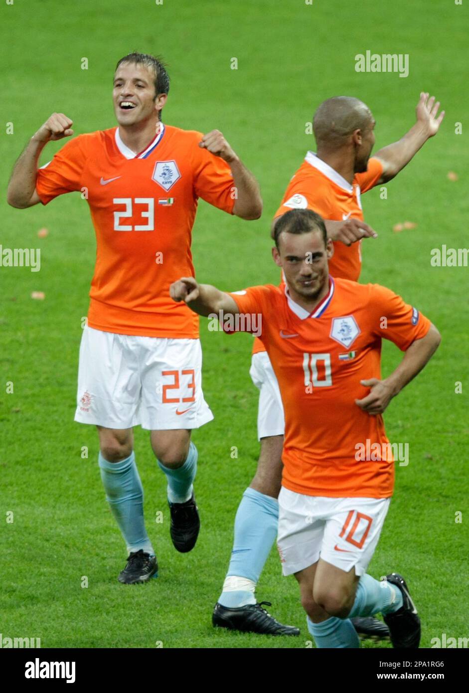 Netherlands' Wesley Sneijder, front, celebrates scoring his side's second goal, as fellow team members Rafael va der Vaart, left, and Nigel de Jong, right, react during the group C match between the Netherlands and Italy in Bern, Switzerland, Monday, June 9, 2008, at the Euro 2008 European Soccer Championships in Austria and Switzerland. (AP Photo/Niklas Larsson) Stockfoto