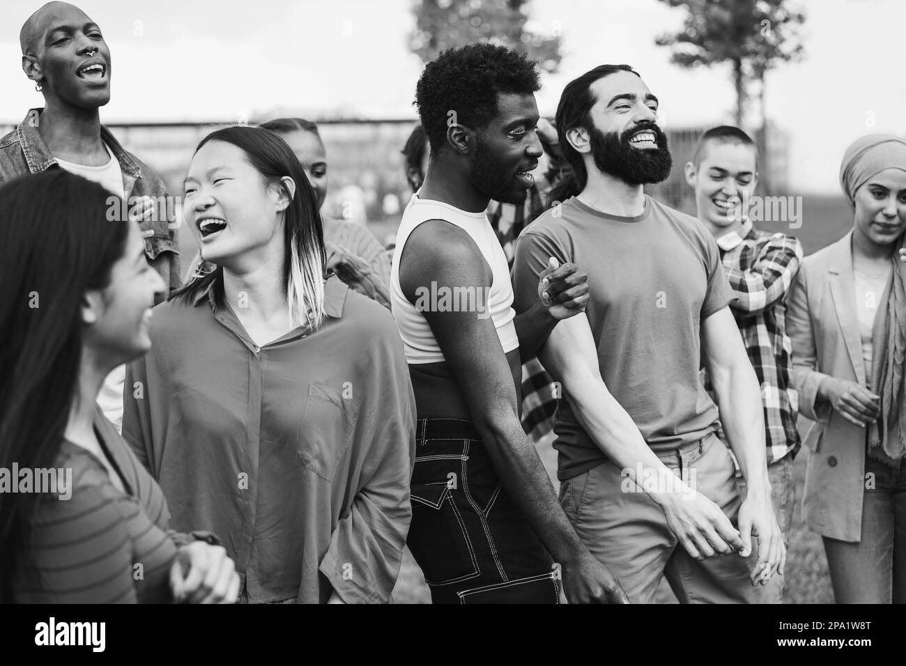 Junge, vielfältige Menschen, die gemeinsam im Freien tanzen - Schwerpunkt auf afrikanischem Schwulengesicht - Schwarz-Weiß-Bearbeitung Stockfoto