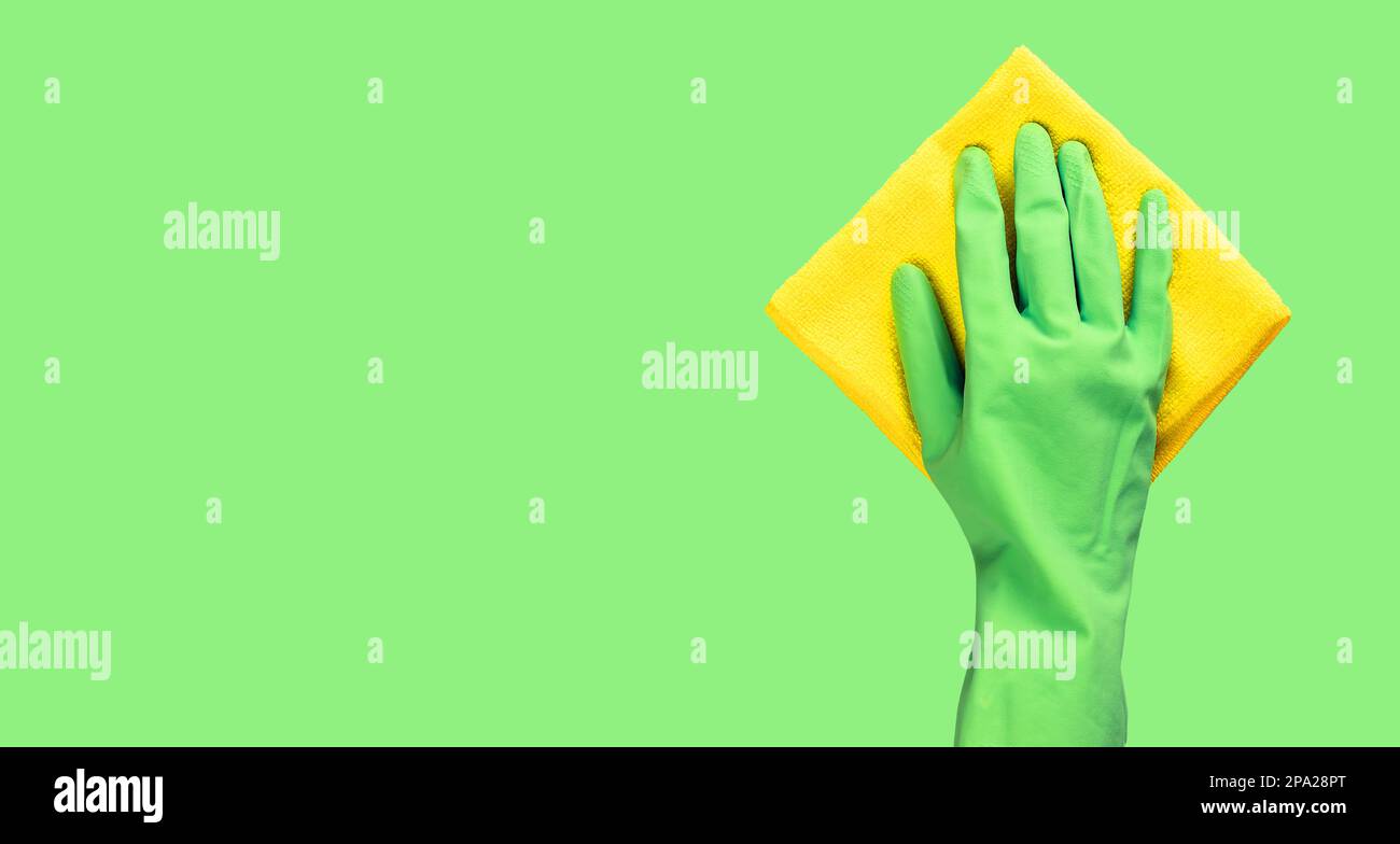Grüner Handschuh mit Mikrofasertuch zum Abwischen. Bannerhintergrund mit Kopierbereich für Text. Stockfoto