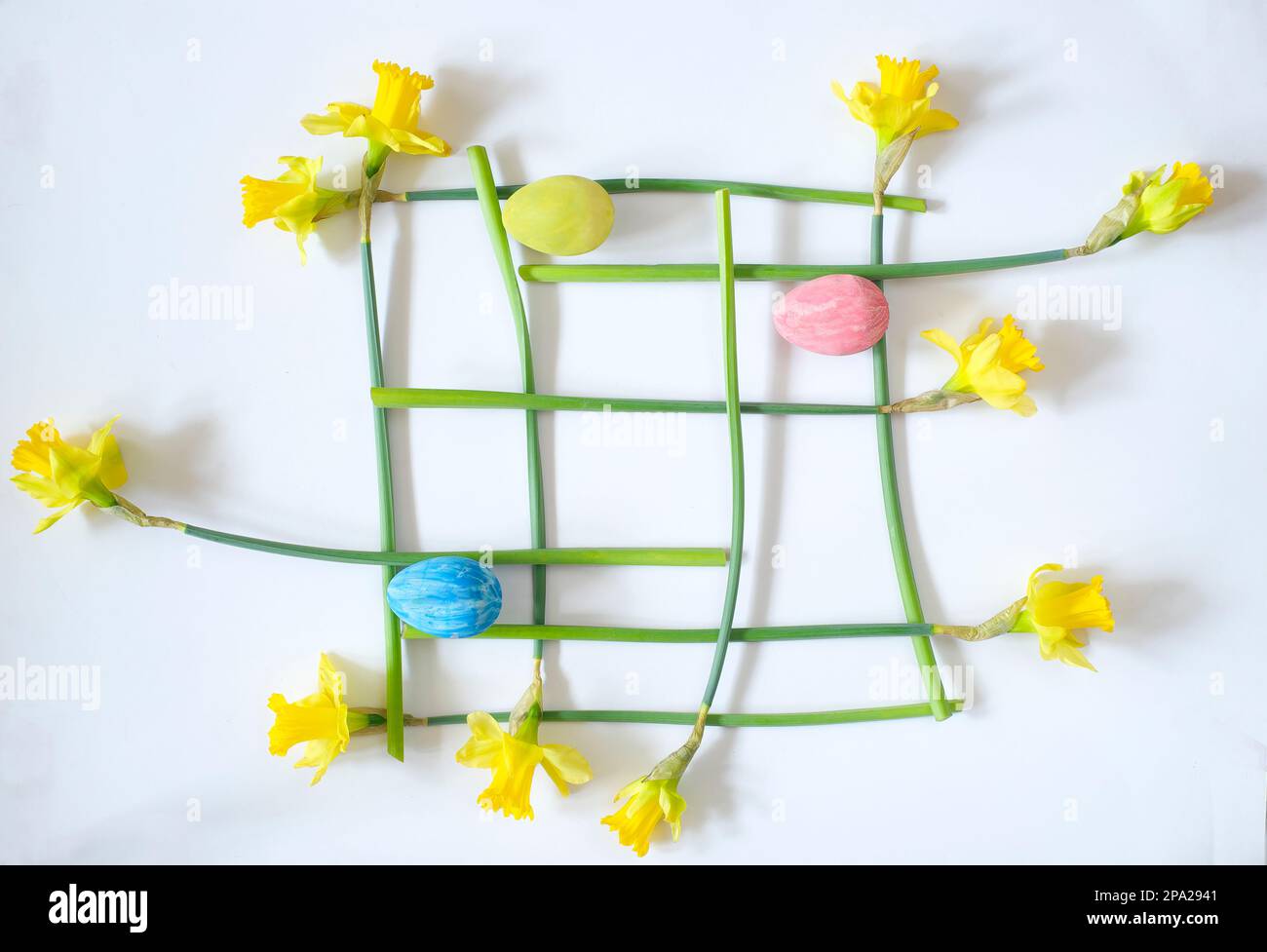 osterdekoration mit handbemalten ostereiern und Narzissenblüten, moderne Kunst inspirierte flache Bettwäsche Stockfoto