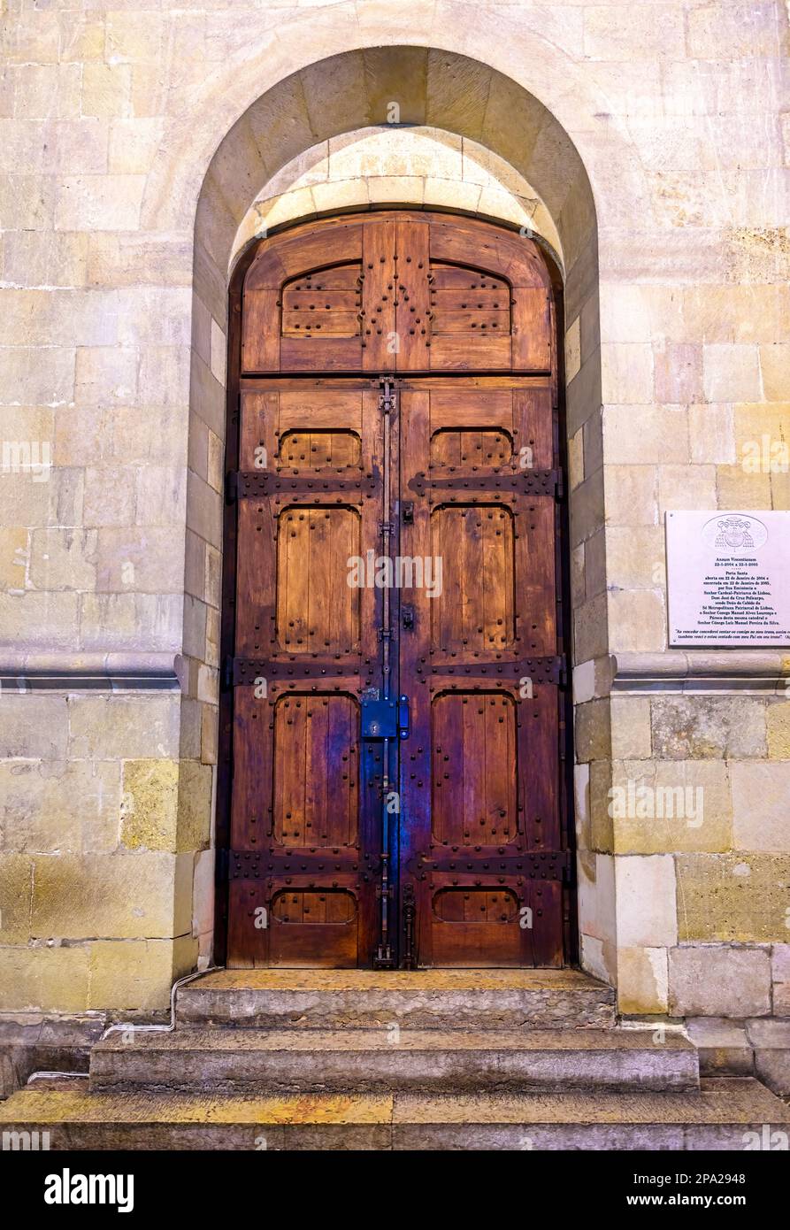 Eine alte hölzerne Tür mit einer historischen Tafel an der Seite. Stockfoto