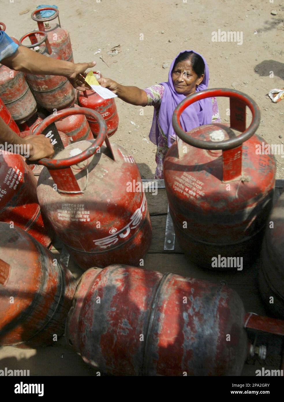 A worker takes a receipt from a woman before handing over a gas