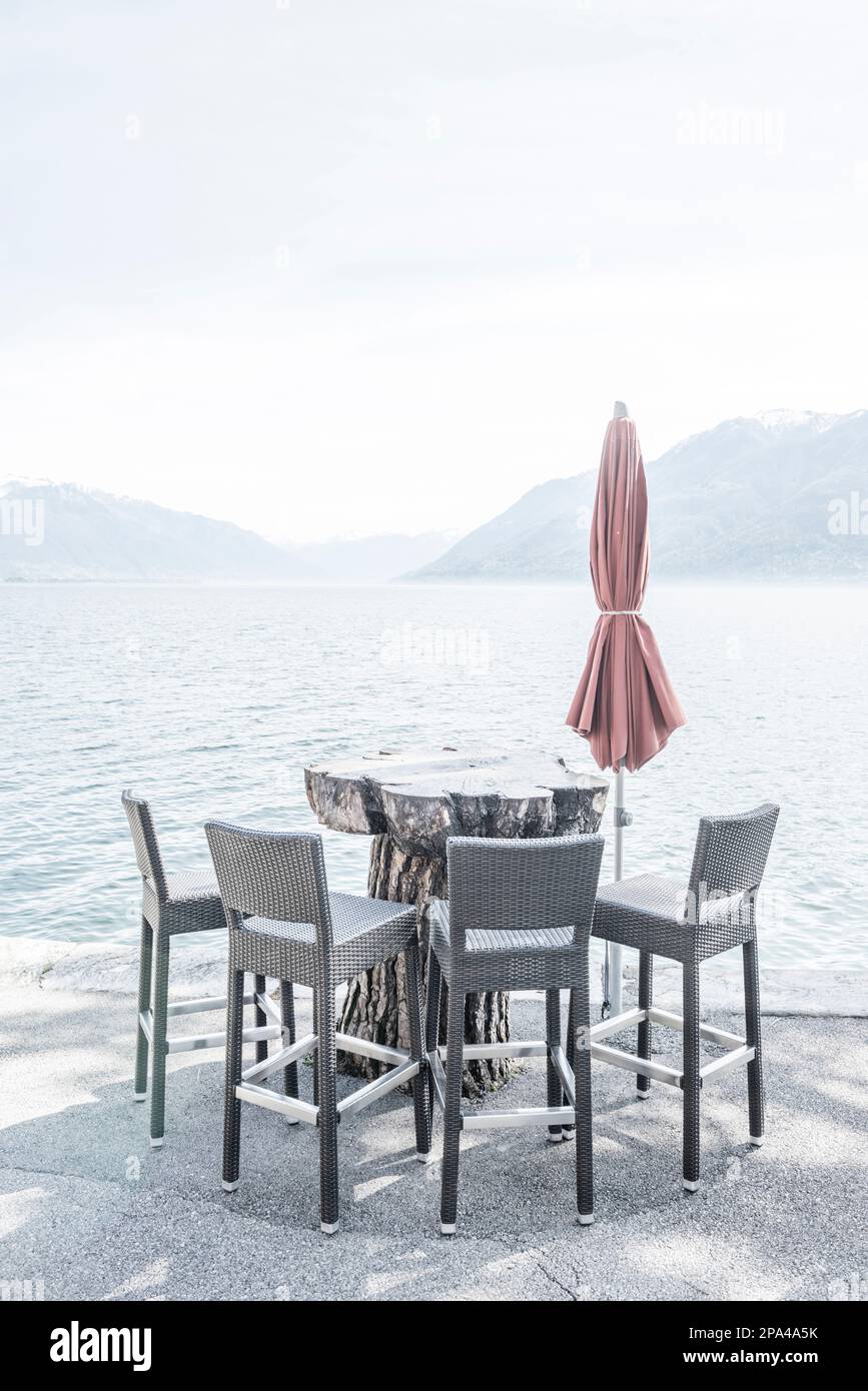 Stuhl und Tisch am Ufer mit Berg in Ascona, Tessin, Schweiz Stockfotografie  - Alamy
