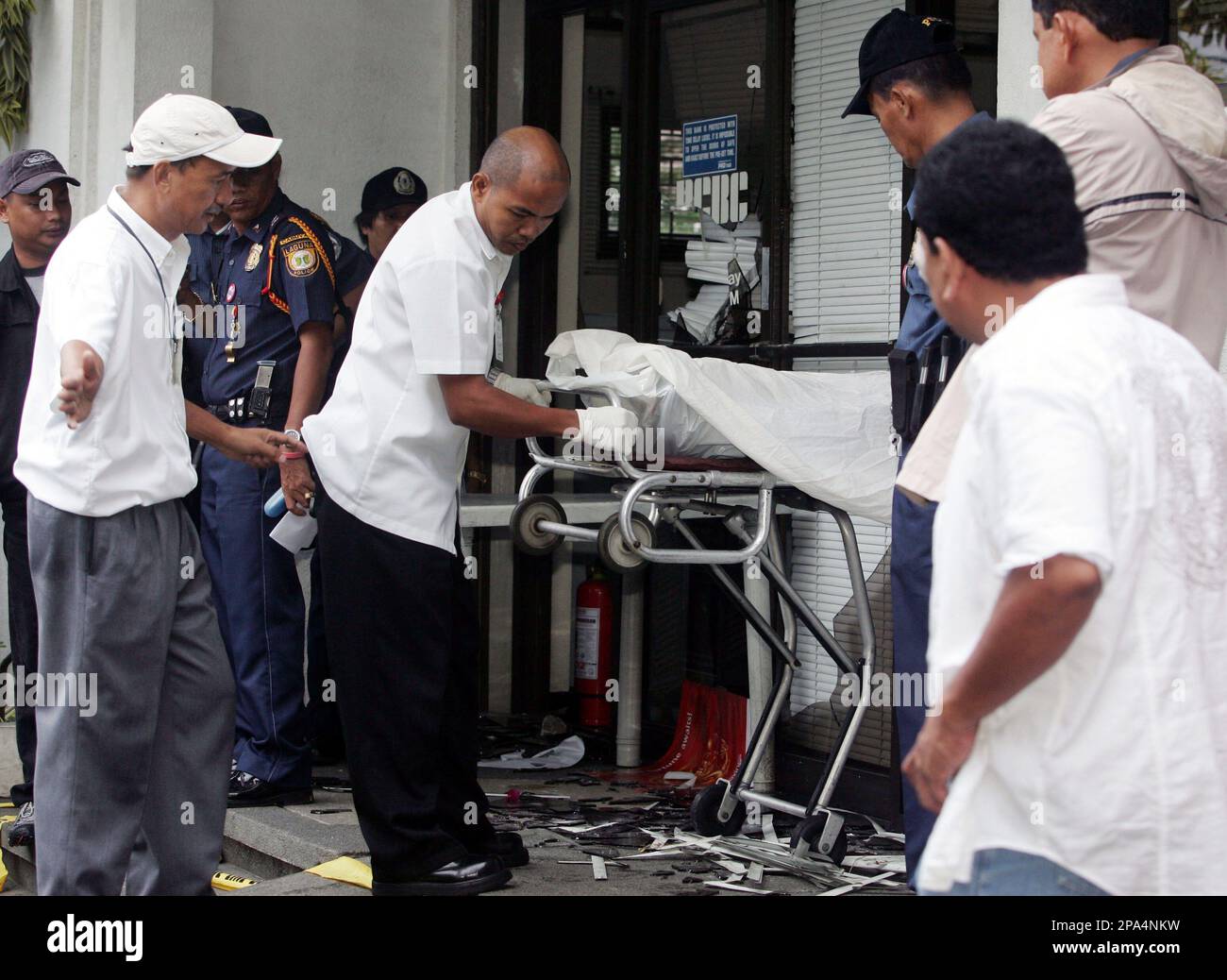 The body of one of nine victims is taken out of the RCBC Bank following a deadly robbery, in Cabuyao, Laguna province 40 kilometers (25 miles) south of Manila, Philippines Friday May 16, 2008. Unknown men robbed the Rizal Commercial Banking Corporation Friday, lined up seven bank employees, a bank client and a security guard and shot them in the head in what is being described as the country's bloodiest bank robbery, police said. One bank employee is in critical condition. (AP Photo/Bullit Marquez) Stockfoto