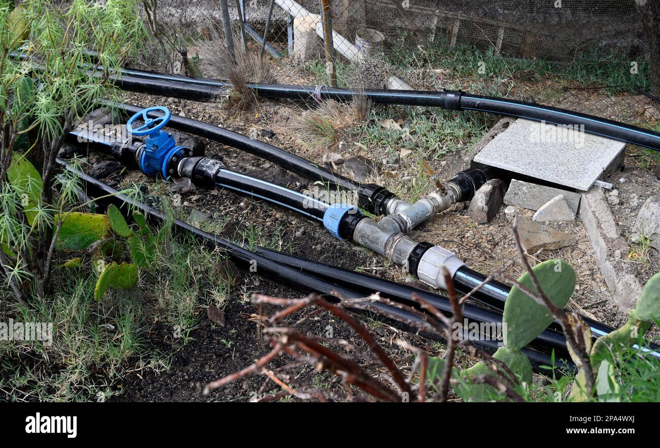 Kunststoffwasserrohre auf dem Land mit Ventilen und „T“-Abzweigungen am Boden, Wasser für kleine landwirtschaftliche Felder, Gran Canaria, Spanien Stockfoto