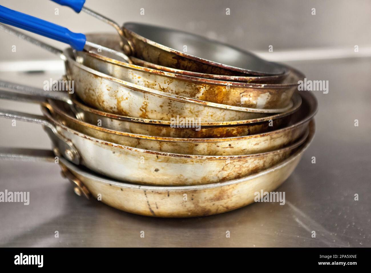 Stapel von verschmutzt, abgenutzt Aluminium Töpfe in einem Restaurant Küche Stockfoto