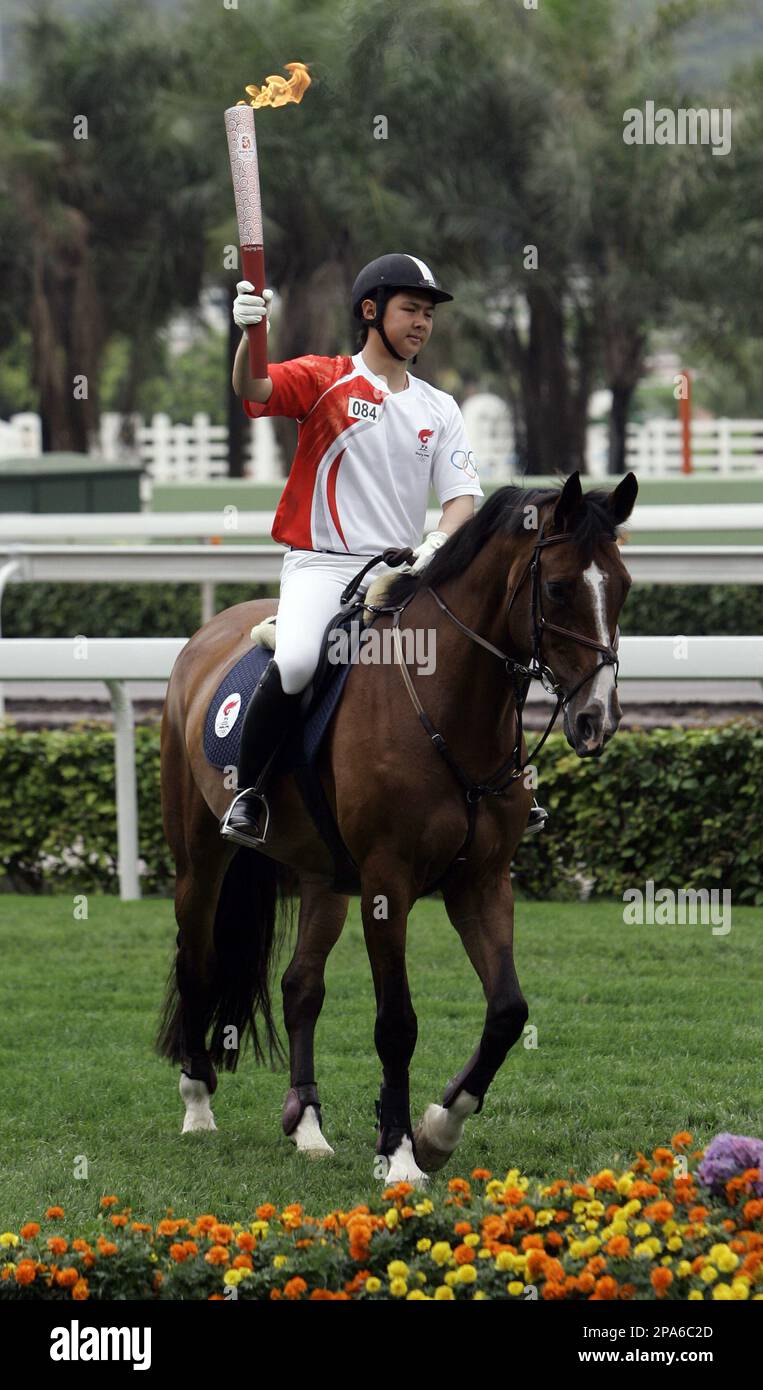 Hong Kong horse rider Cheng Man-kit rides with the Olympic torch at Shatin Racecourse in Hong Kong Friday, May 2, 2008. Friday's torch relay over highways, bridges and through canyons of skyscrapers was a big challenge for Hong Kong's leaders and police. The torch was finally back on Chinese soil, and Beijing wanted no repeat of the protests and chaos that disrupted the flame during its 20-nation overseas tour. (AP Photo/Kin Cheung) Stockfoto
