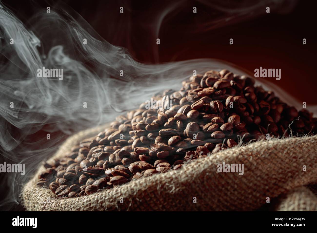 Mittelgeröstete Kaffeebohnen sind in einem Leinenbeutel rauchig. Stockfoto