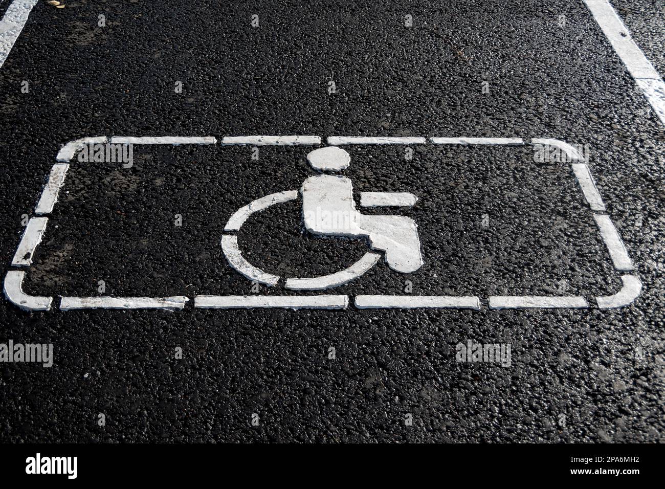 Behindertensymbol auf der Straße. Straßenmarkierung auf Asphalt mit Behindertenparkplätzen. Rollstuhl-Symbol für Behindertenparkplatz für Behinderte Stockfoto