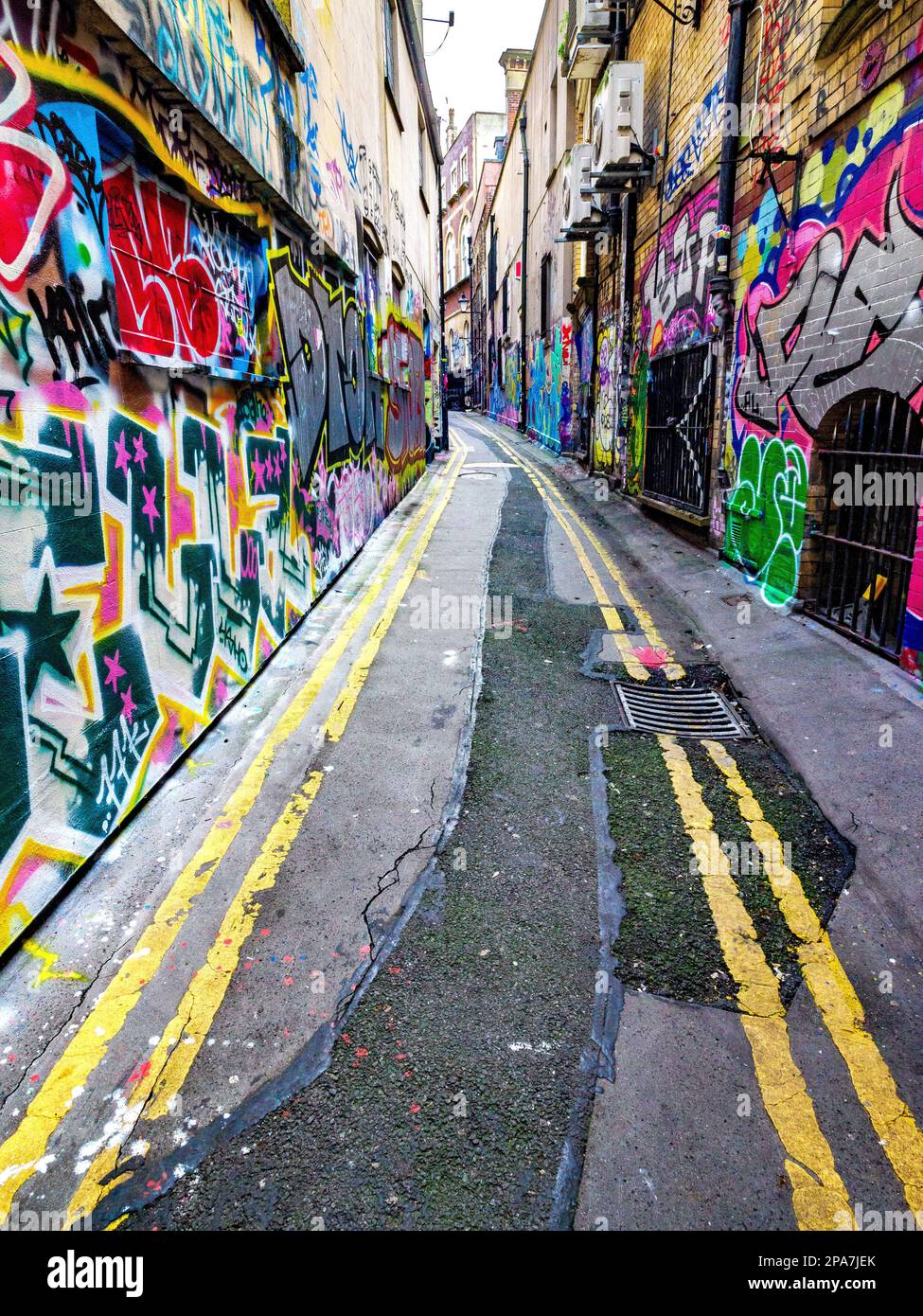 Farbenfrohe, mit Graffiti bedeckte Wände einer engen Gasse in der Nähe der Corn Street in der Altstadt von Bristol UK Stockfoto