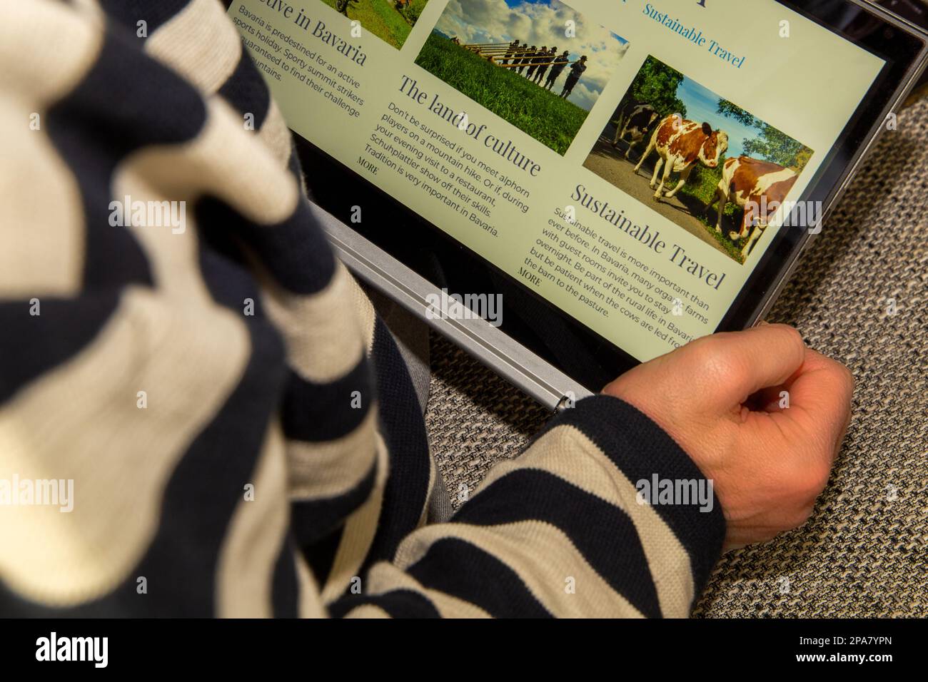 Symbol-Bildreisen, Reiseplanung: Der Mensch informiert sich über Bayerurlaube auf einer (virtuellen) englischsprachigen Website Stockfoto