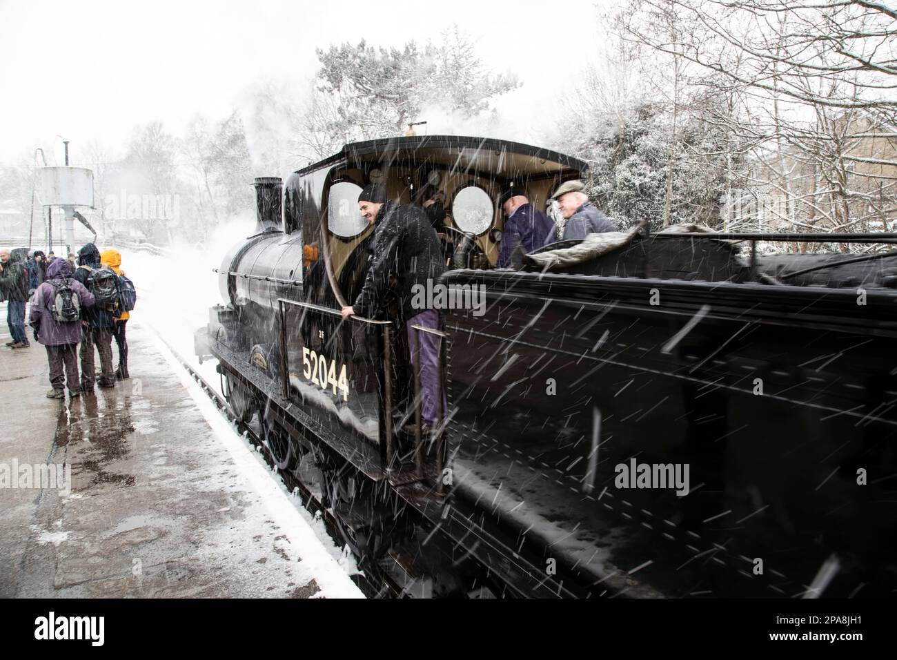 Dampflokomotive 52044 Klasse 25 Ironclad, die im Film "Railway Children" mitspielte, fährt bei einem Schneesturm in die Station Oxenhope Stockfoto