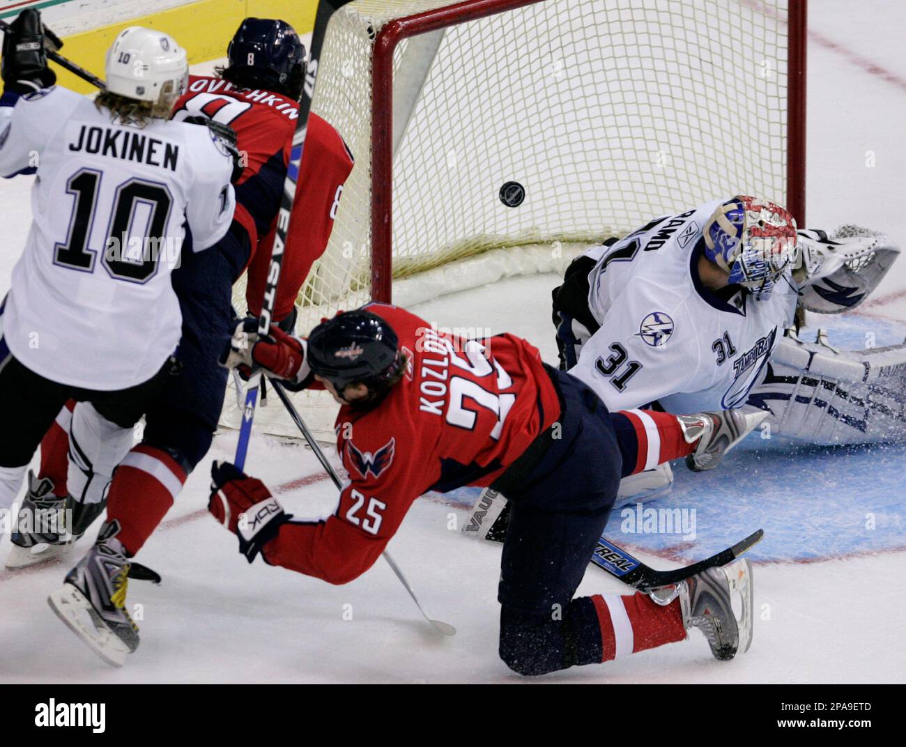 Washington Capitals center Viktor Kozlov (25), of Russia, falls to the ice after scoring against Tampa Bay Lightning goalie Karri Ramo, right, of Finland, during the first period of an NHL hockey game, Thursday, April 3, 2008, in Washington. At left is Lightning left wing Jussi Jokinen (10) and Capitals left wing Alexander Ovechkin, also of Russia. (AP Photo/Haraz N. Ghanbari) Stockfoto