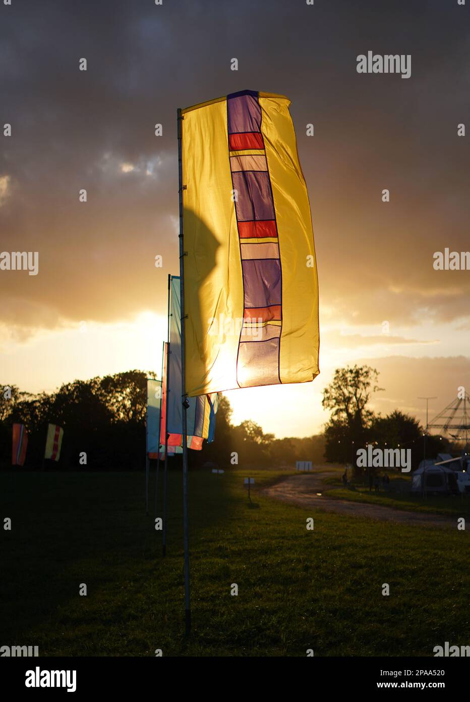 Farbenfrohe Banner auf der Worthy Farm, Pilton, dem Veranstaltungsort des Glastonbury Festivals, am frühen Abend bei Sonnenuntergang. Stockfoto