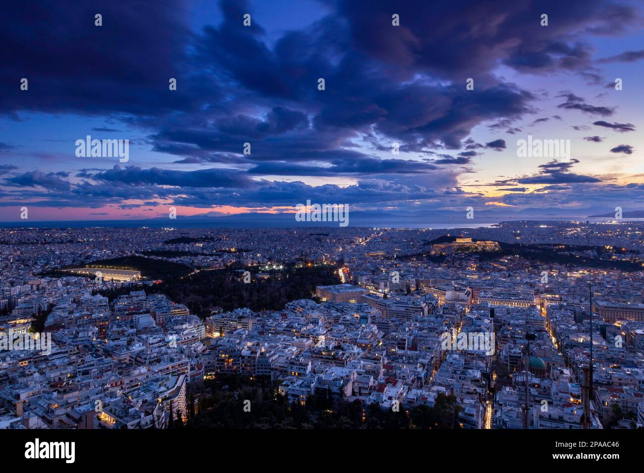 Blick auf die Stadt Athen während eines herrlichen Sonnenuntergangs. Auf der rechten Seite sehen Sie die Akropolis und den Parthenon, und auf der unteren linken Seite das Parlament. Stockfoto