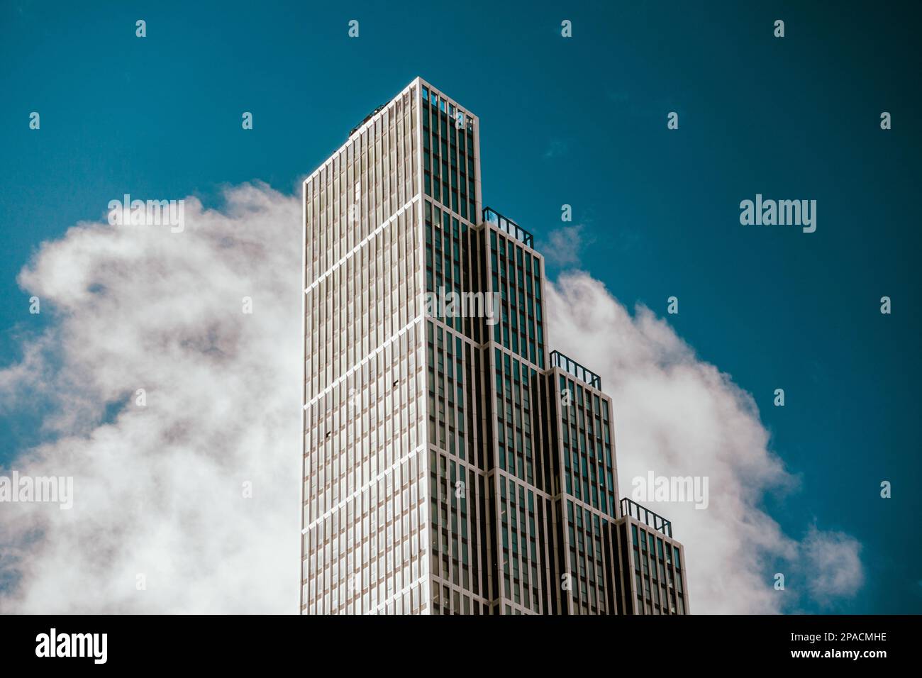 Hoher Turmblock vor blauem Himmel und Wolken, Apartmentgebäude, Wohnungen, moderne Architektur in der Skyline der Stadt Stockfoto