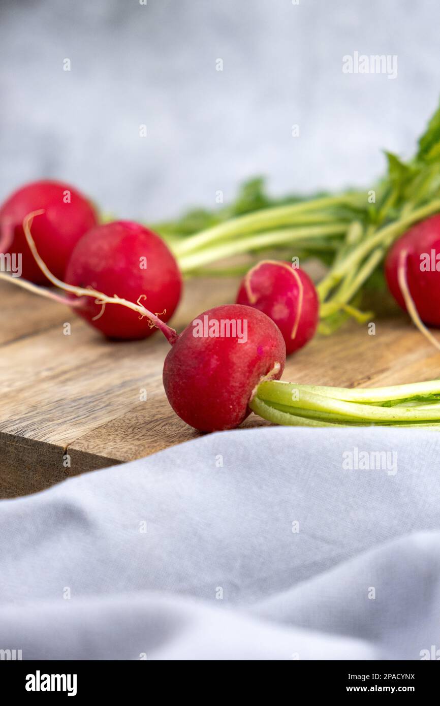 Frischer Rettich auf einem Holzbrett, vertikales Foto Stockfoto