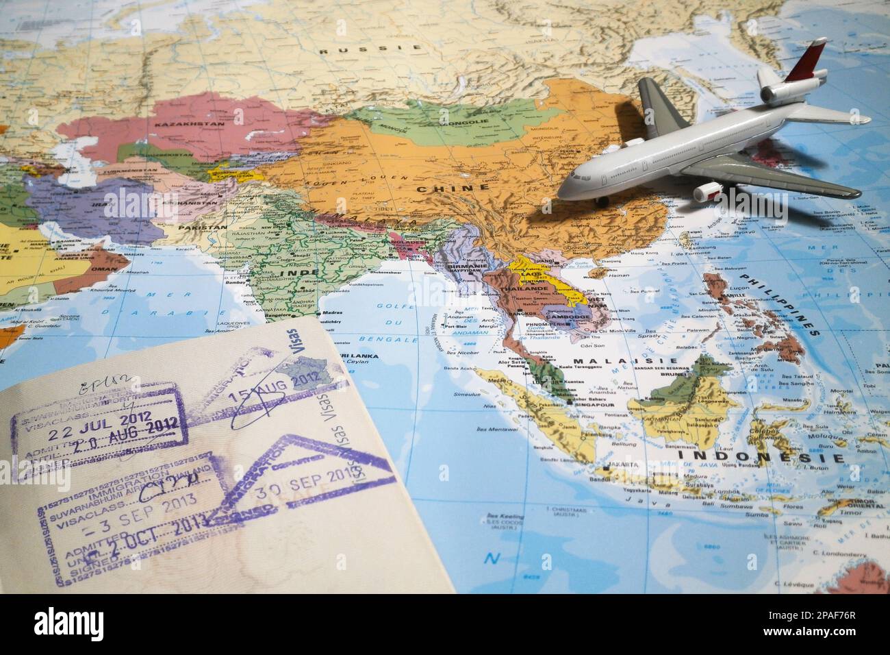 Bangkok, Thailand - Februar 19 2019: Die Komposition besteht aus einer Weltkarte, die in Asien zentriert ist, mit einem Spielzeugflugzeug und der Seite eines Passes mit Ar Stockfoto
