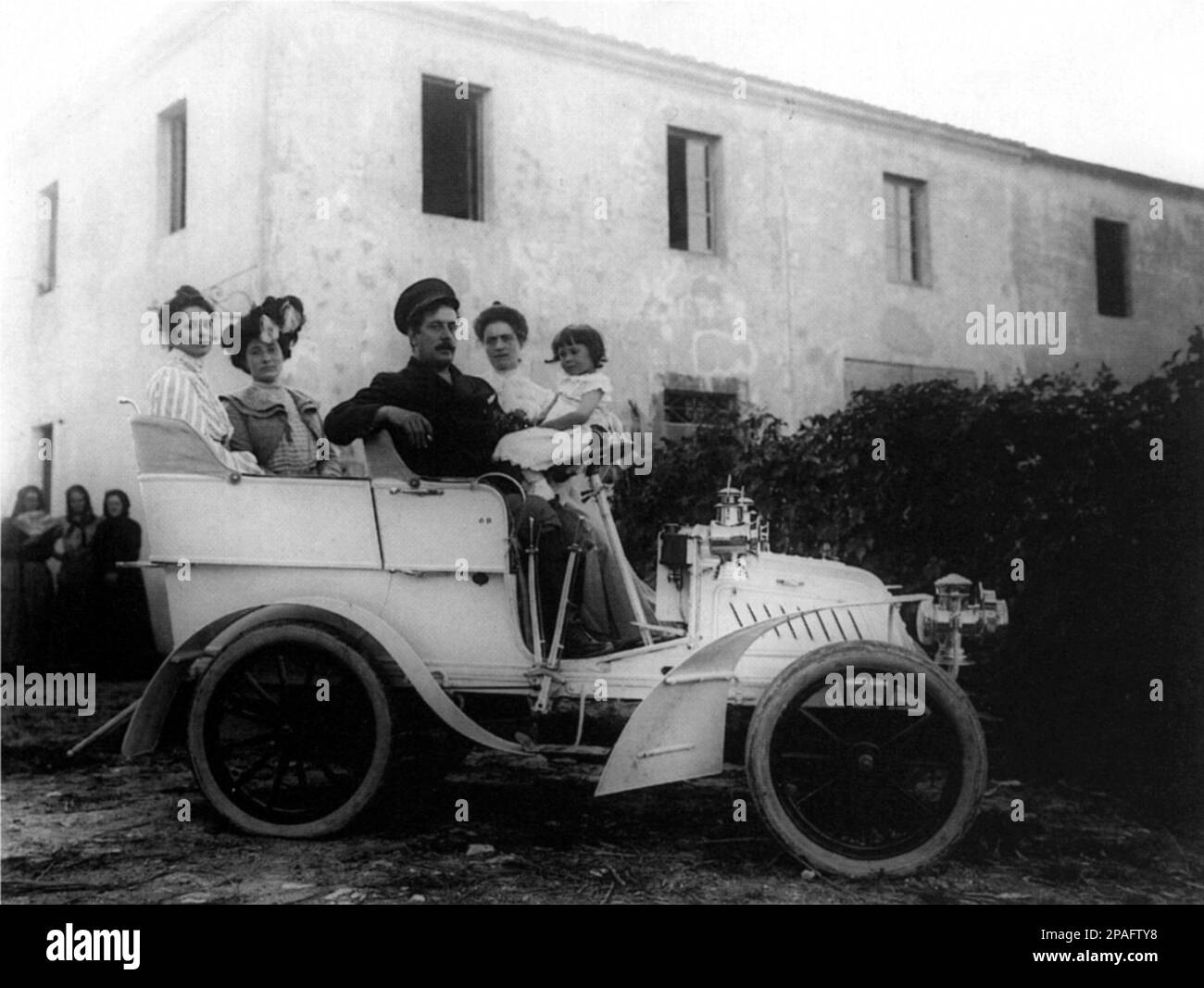 1902 , Torre del Lago , Lucca , Italien : der gefeierte italienische Komponist GIACOMO PUCCINI 1858 - 1924 ) im Auto De Dion Bouton " 5 CV " mit ihm : seine Frau ELVIRA BONTURI ( verheiratet Germiniani , rechts auf dem Foto ) Mit der kleinen Enkelin ELVIRA LEONARDI ( später heiratete BOYEURE , feierte Modedesignerin mit Namen BIKI ), FOSCA LEONARDI ( geboren GEMINIANI , Mutter von Biki , mit Hut ) - OPERA LIRICA - COMPOSITORE - MUSICA - Portrait - ritratto - Baffi - Schnurrbart - CLASSICA - KLASSISCH - COMPOSITORE LIRICO - Portrait - ritratto - Hut - cappello - automobil Stockfoto