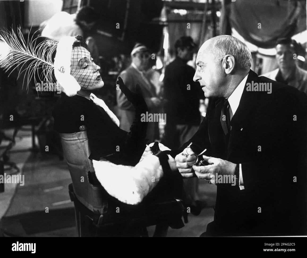 1951 : die Filmdarstellerin GLORIA SWANSON ( Chicago 1898 - New York 1983 ) als Norma Desmond in SUNSET BOULEVARD ( Viale del Tramonto ) von Billy Wilder , Kostüm von Edith HEAD , Paramount Publicity noch immer . Auf diesem Foto mit Filmregisseur CECIL B. DE MILLE - FILM - KINO - attrice cinematografica - VAMP - DIVA - DIVINA - GÖTTLICH - Hollywood on Hollywood - Pelz - lange Handschuhe - Guanti Lunghi - Hut - cappello - Veletta - verschleiert - Piuma di pavone - Feder ---- ARCHIVIO GBB Stockfoto