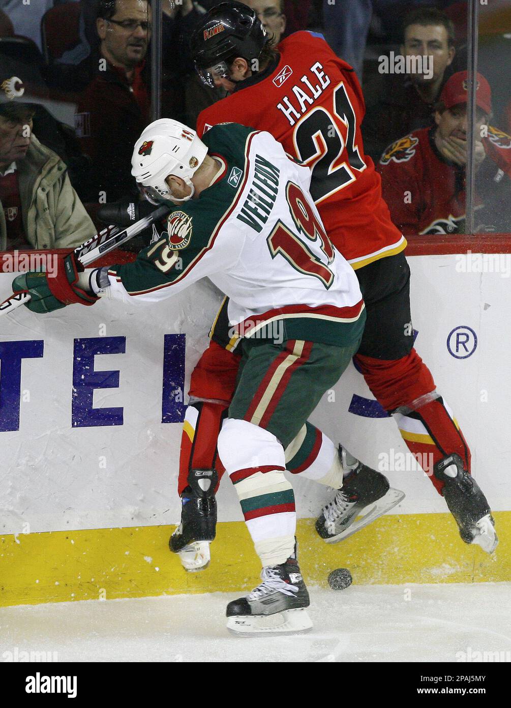 Calgary Flames' David Hale, right, is checked off the puck by Minnesota Wild's Stephane Veilleux, left, during the first period of an NHL hockey game in Calgary, Alberta, on Tuesday, Jan. 22, 2008. (AP Photo/The Canadian Press, Larry MacDougal) Stockfoto