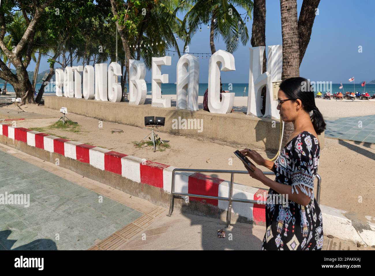 Eine weibliche asiatische Tourist passiert das Wahrzeichen „Patong Beach“, ein beliebter Fotomotiv in Patong Beach, Phuket, Thailand Stockfoto