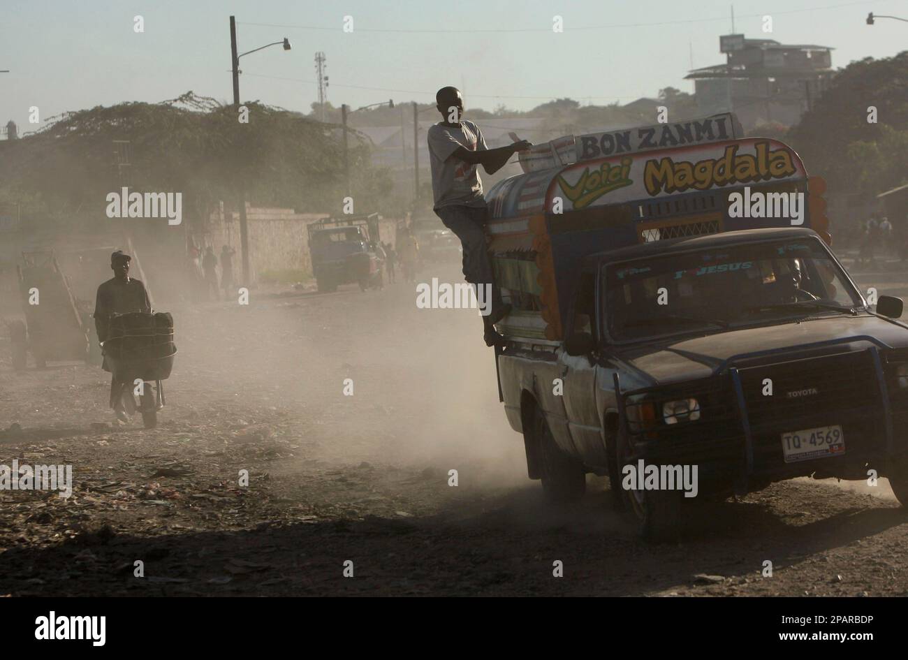 A man rides on the back of a public transportation van called 'TAP TAP' in Port-au-Prince, Friday, Nov. 30, 2007. Haiti is by far the poorest country in the Western hemisphere, with poverty levels approaching those of parts of Africa and southeast Asia. About 80% of the population lives in abject poverty, engaged mainly in subsistence agriculture. (AP Photo/Ariana Cubillos) Stockfoto