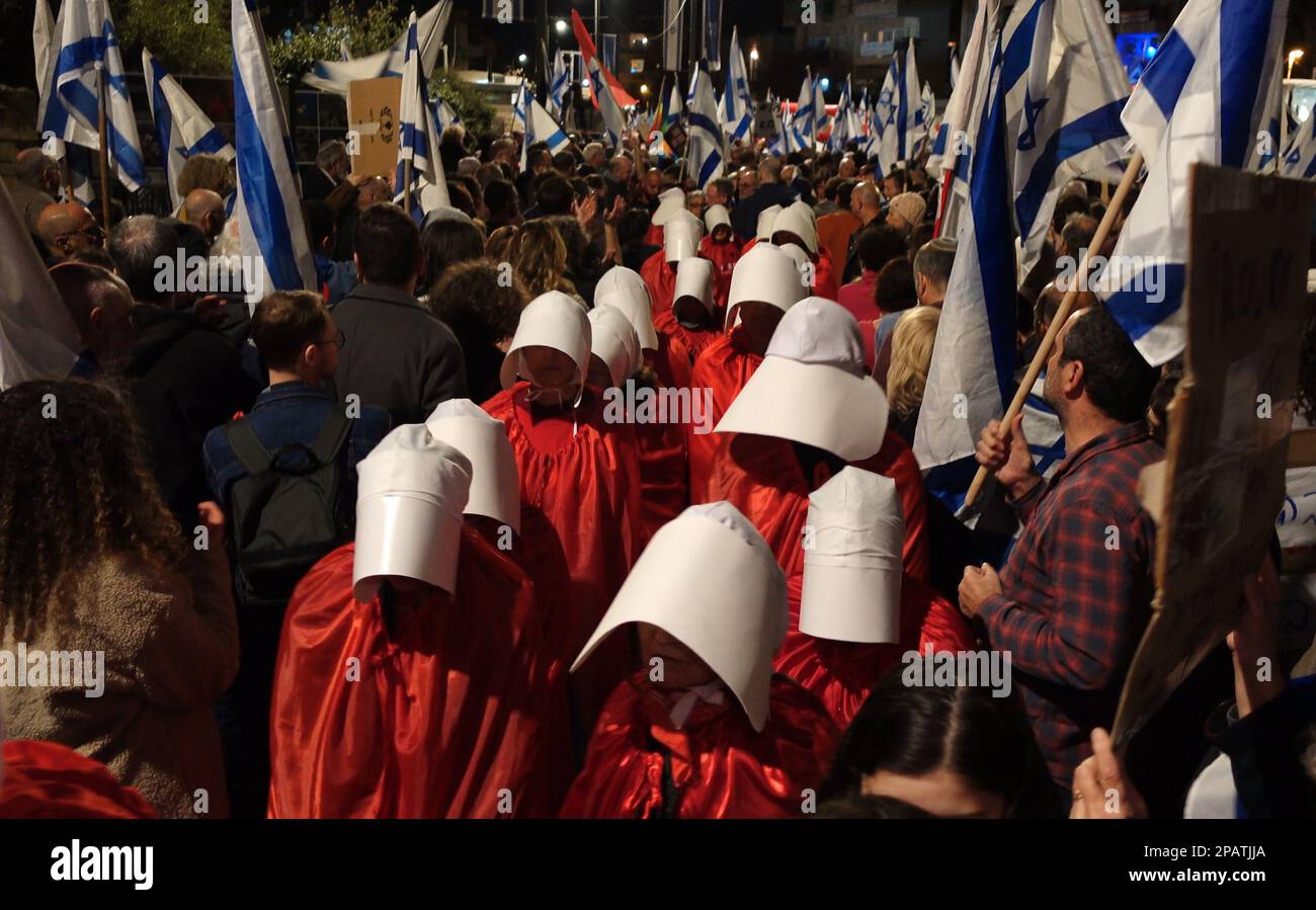 JERUSALEM, ISRAEL - MÄRZ 11: Dutzende regierungsfeindlicher Demonstranten in langen roten Kleidern und weißen Kopfbedeckungen, Nehmen Sie wie die Dienstmädchen in dem Roman von Margaret Atwood "die Geschichte der Magd" an einer Demonstration gegen Israels neuen Plan des Justizsystems Teil, der darauf abzielt, den Obersten Gerichtshof des Landes außerhalb der Residenz des Präsidenten am 11. März 2023 in Jerusalem, Israel, zu schwächen. Kredit: Eddie Gerald/Alamy Live News Stockfoto