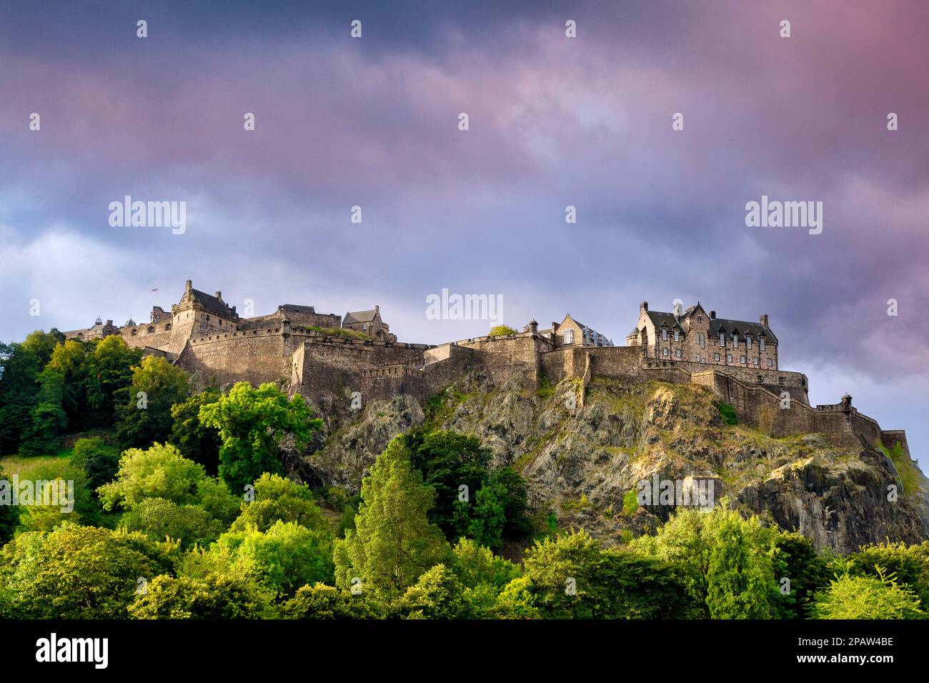 Edinburgh Castle, hoch oben auf dem Felsen über den Bäumen der Princes Street Gardens. Stockfoto