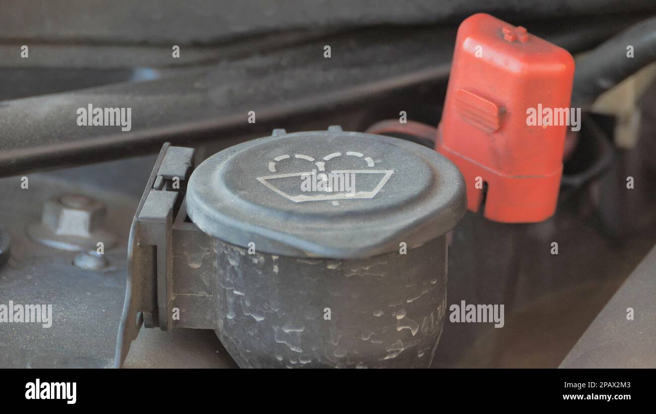 Nahaufnahme des Wasserdeckels der Windschutzscheiben-Waschanlage eines Tanks für Scheibenwischer. Stockfoto