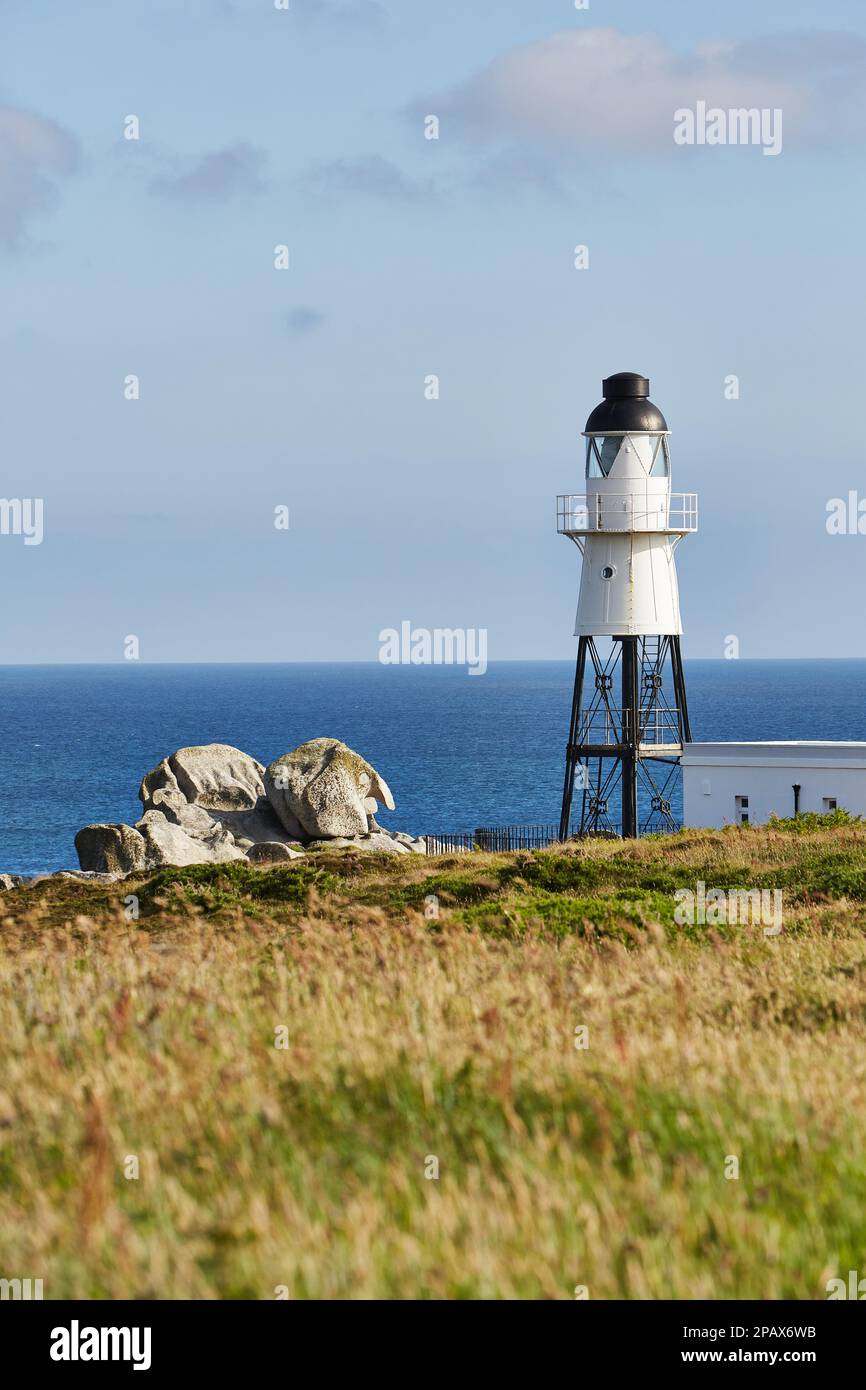 Isles of Scilly, Großbritannien - Peninnis Lighthouse an einem sonnigen Herbsttag mit Felsen, Meer und Gras. Vertikales Bild Stockfoto