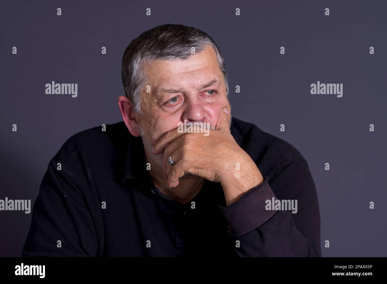 Nettes, unauffälliges Porträt eines bärtigen Ukrainers, der in der Dunkelheit meditiert Stockfoto