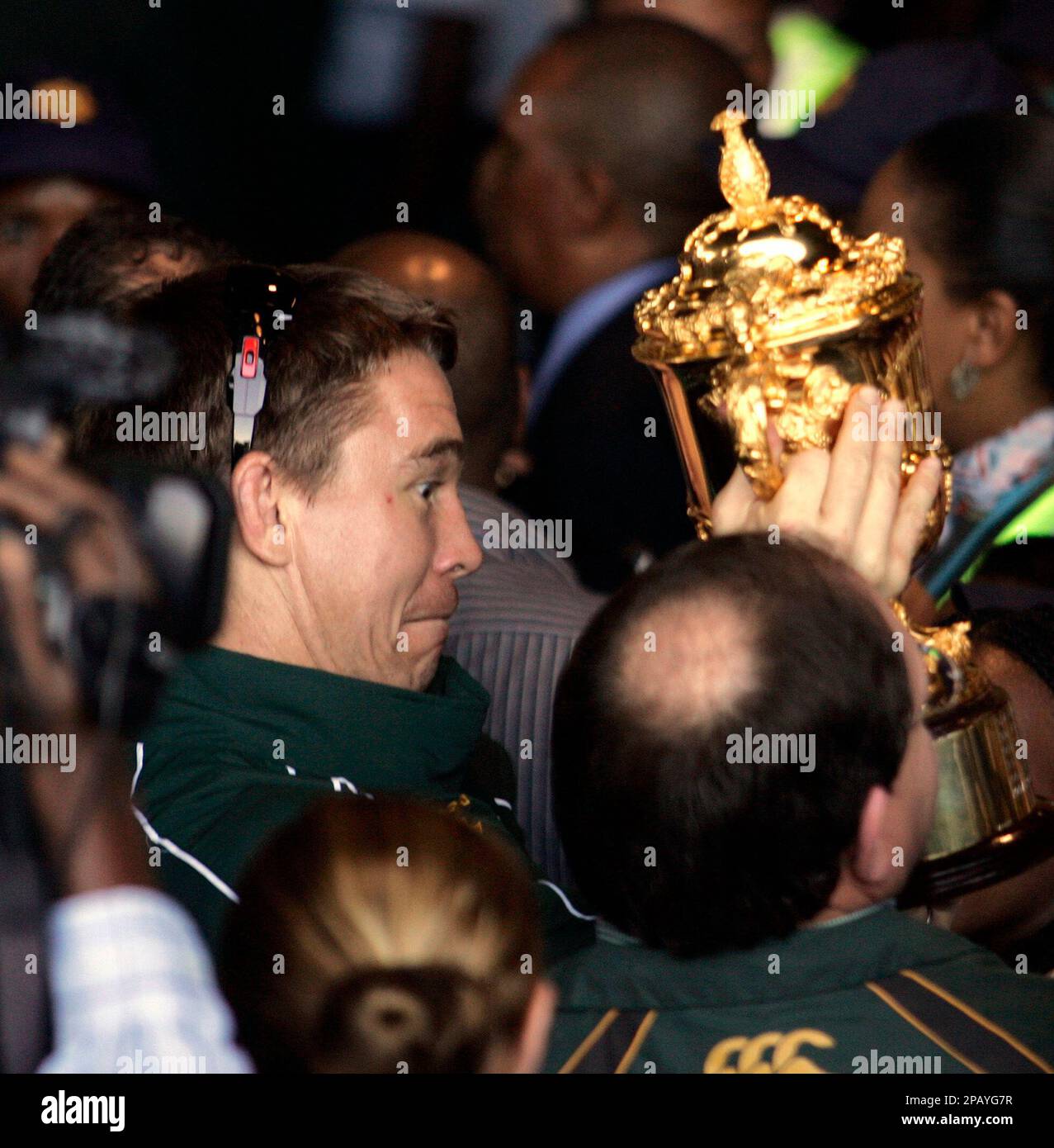 ** RETRANSMISSION FOR ALTERNATE CROP ** South Africa's Springbok, rugby team captain John Smit, reacts as he lifts the William Webb Ellis trophy, to show to supporters on the teams arrival in Johannesburg, Tuesday Oct. 23, 2007. A sea of green and gold greeted South Africa's victorious rugby team on its return home Tuesday after winning the Rugby World Cup in France. South Africa beat England 15-6 in a convincing win in Paris on Saturday. (AP Photo/Themba Hadebe) Stockfoto