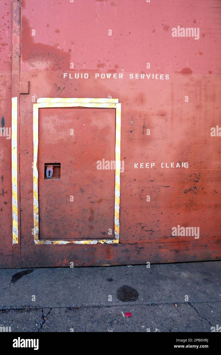 Rot lackierte Stahltür mit Schild „Keep Clear“ Stockfoto