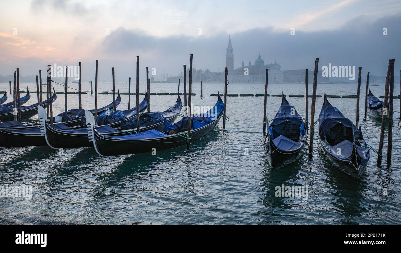 Venedig, Italien - 15. November 2022: Morgenblick auf Gondeln, den Canale Grande und den Glockenturm San Giorgio Stockfoto