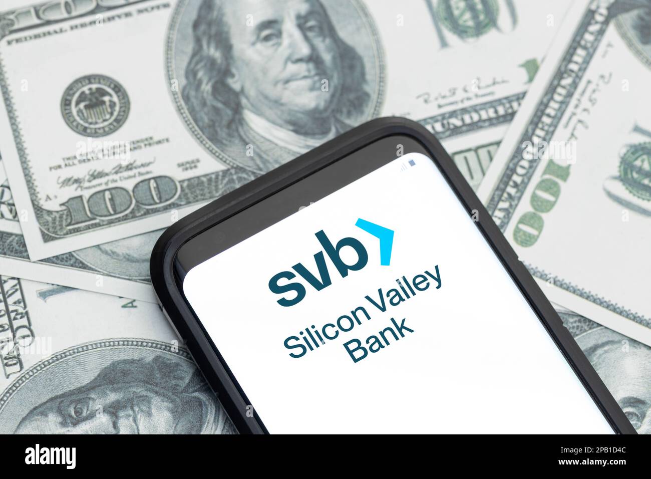 Galicien, Spanien; 12. märz 2023: Logo des Finanzdienstleisters der Silicon Valley Bank auf dem Smartphone-Bildschirm und Hintergrund der Dollarscheine Stockfoto