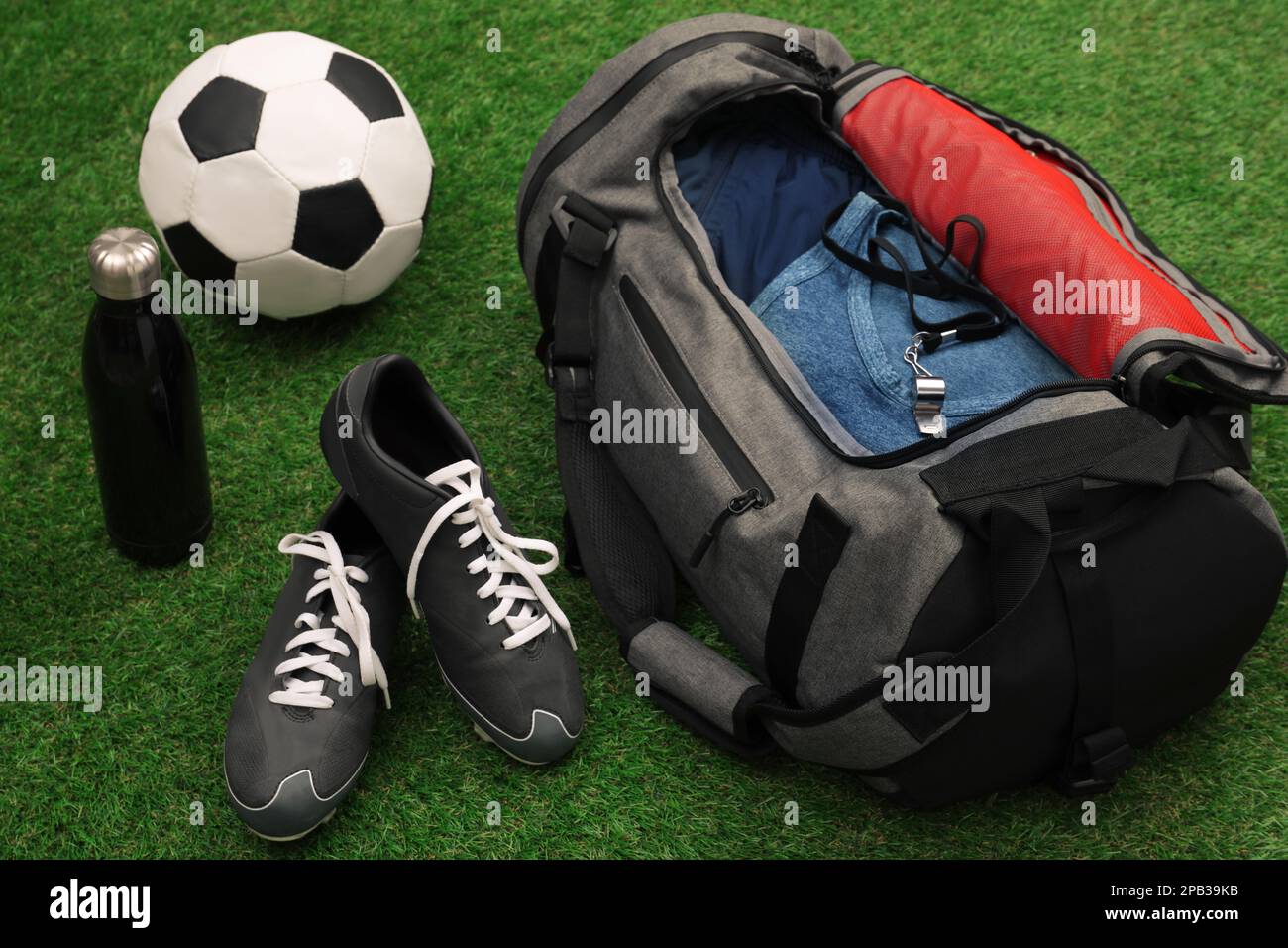 Sporttasche und Sportausrüstung auf grünem Gras Stockfoto