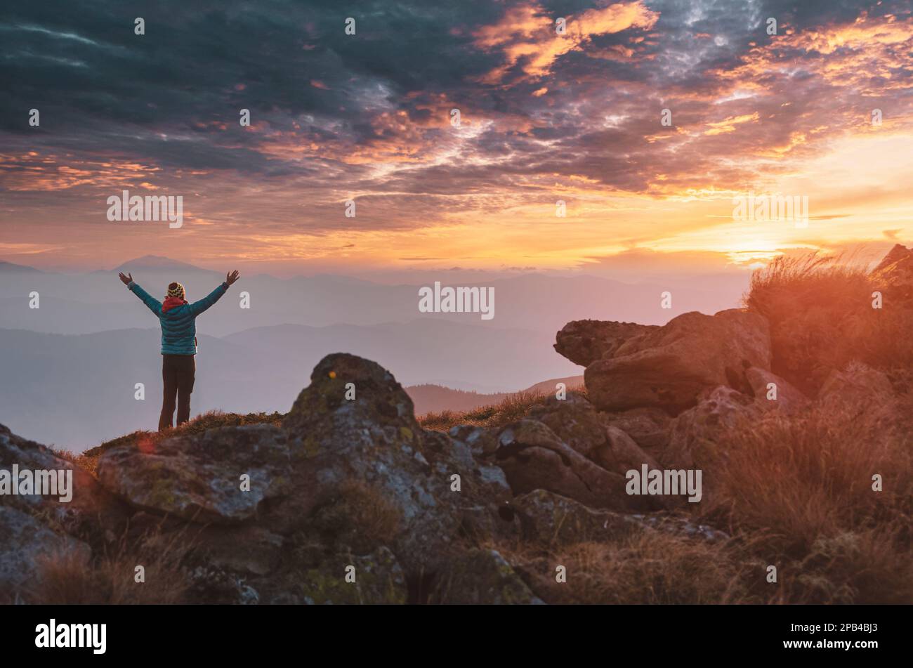 Einsamer Tourist trifft auf Sonnenuntergang in den Bergen. Outdoor-Aktivitäten und Erkundungskonzept Stockfoto
