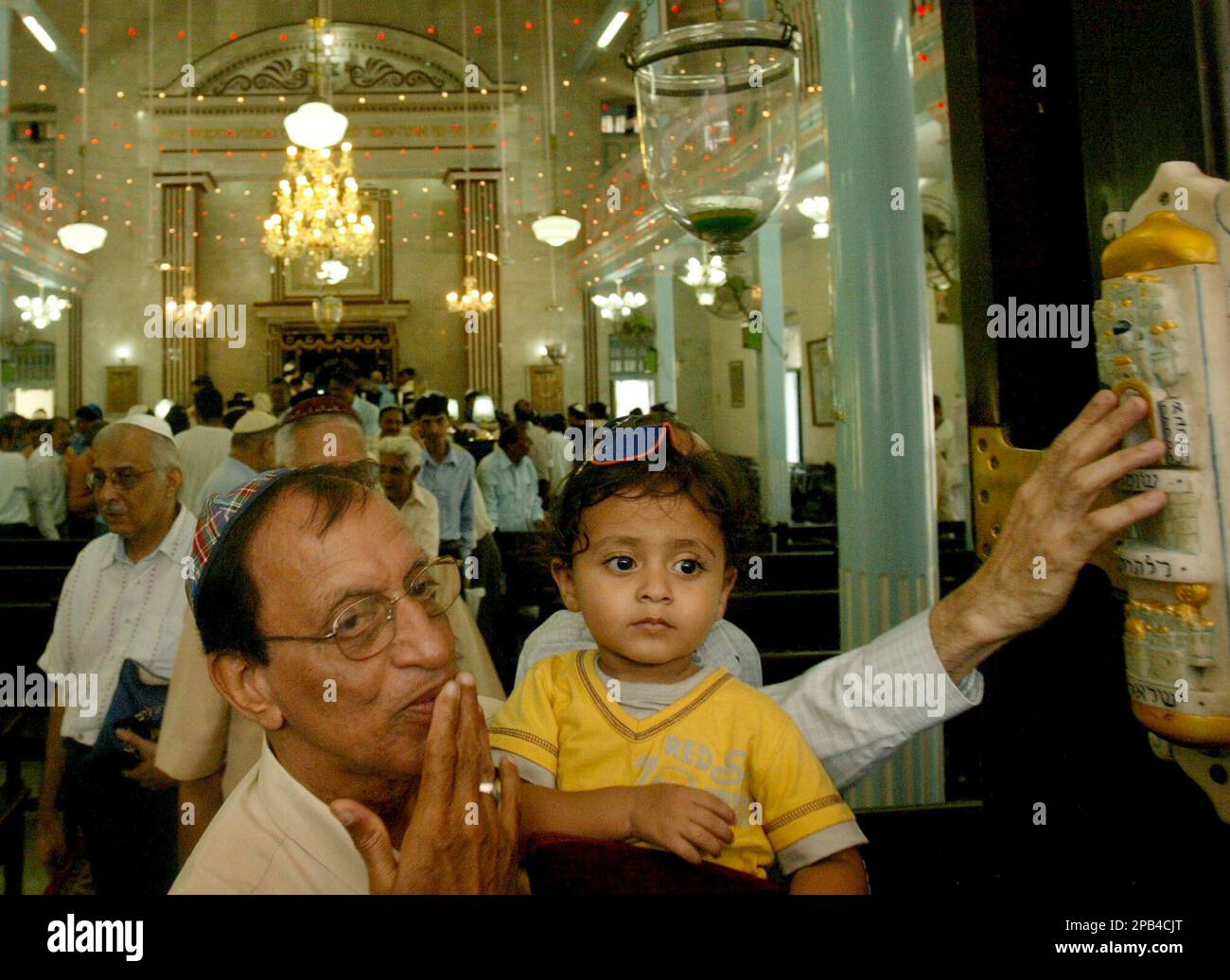 Indian Jews touch the 'Mezuzah', right, a piece of parchment inscribed