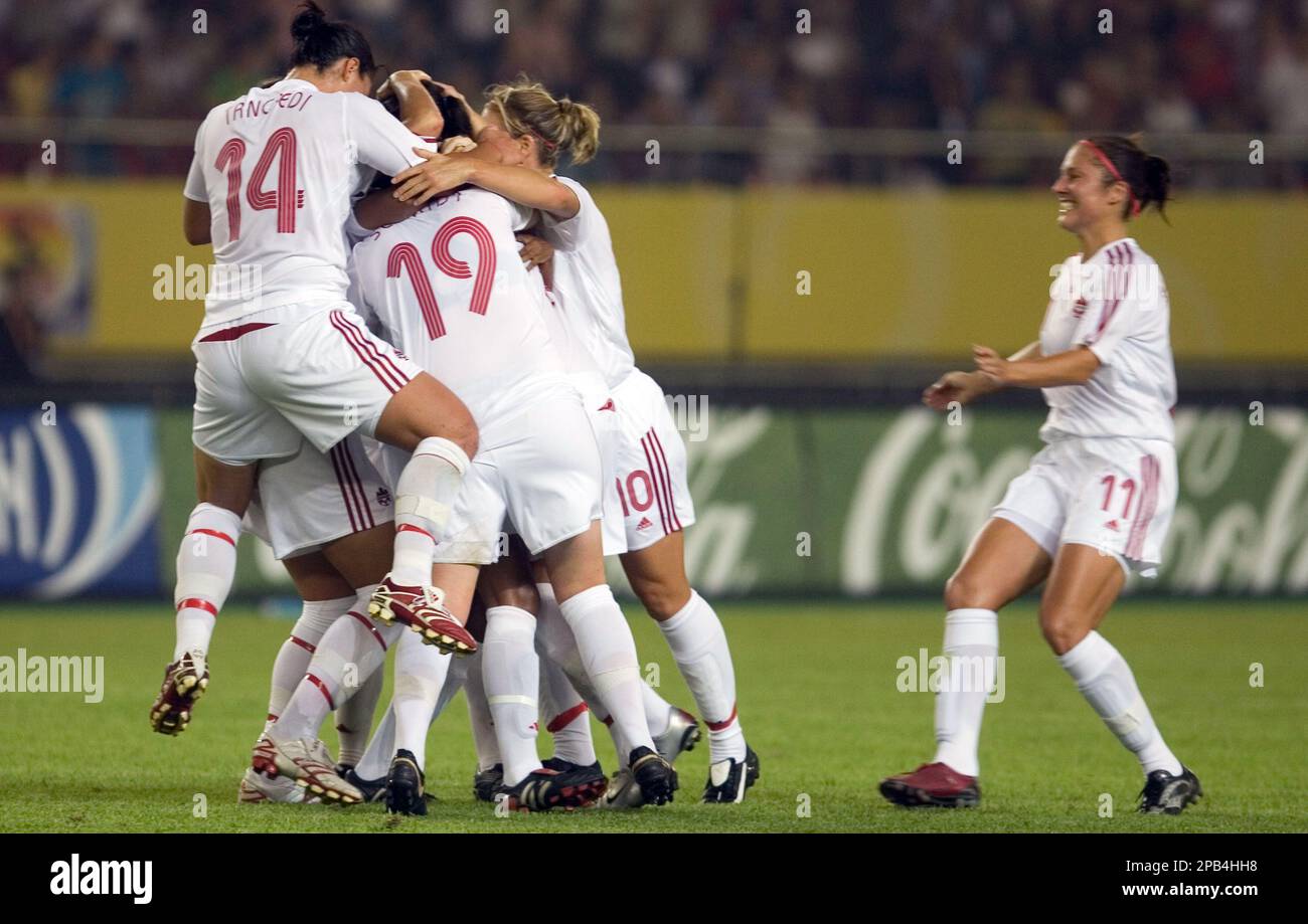 Canada's Melissa Tancredi, (14) and Sophie Schmidt, (19) surround Candace-Marie Chapman, unseen as Randee Hermus, (11) approaches to join in after a goal against Norway during a Group C match for the FIFA Women's World Cup soccer tournament in Hangzhou, eastern China's Zhejiang province, Wednesday, Sept 12, 2007. (AP Photo/Ng Han Guan) Stockfoto